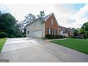 Long concrete driveway leading to a brick and siding home with an attached garage, providing ample parking space at 12043 Olmstead Dr, Fayetteville, GA 30215