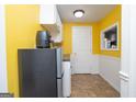 Cozy kitchen features yellow walls, white cabinets, and compact appliances, perfect for efficient meal preparation at 12043 Olmstead Dr, Fayetteville, GA 30215