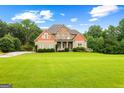 Stunning home exterior with manicured lawn, mature trees, and inviting curb appeal on a sunny day at 360 Grandmas Ln, Fayetteville, GA 30215