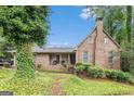 Charming brick home featuring a covered porch and well-maintained landscaping with mature trees at 6230 S Summers Cir, Douglasville, GA 30135