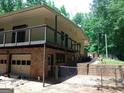 Multi-level home showcasing a spacious back balcony, garage, and brick design at 205 Avon Dr, Fayetteville, GA 30215
