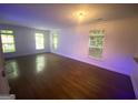 A spacious living room with hardwood floors and natural light streaming through three windows at 241 Perimeter Walk, Atlanta, GA 30338