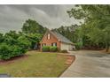 Traditional brick home with attached garage, a well-kept lawn, and plenty of parking at 1917 Kevin Se Dr, Conyers, GA 30013