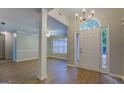 Bright foyer featuring hardwood floors, modern light fixture, and a view into the living room at 1917 Kevin Se Dr, Conyers, GA 30013