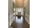Spacious foyer featuring hardwood floors, wainscoting and a bright entry door at 160 Elysian Dr, Fayetteville, GA 30214