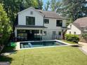 Backyard with an in-ground pool, a well-maintained lawn, and modern architecture at 1168 Mclynn Ne Ave, Atlanta, GA 30306