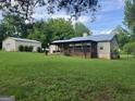 Spacious backyard featuring a large deck, a detached garage, and a lush lawn surrounded by trees at 5761 Hancock Dr, Social Circle, GA 30025