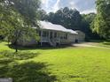 Single story home with metal roof, covered porch, attached garage, and well maintained lawn at 5761 Hancock Dr, Social Circle, GA 30025