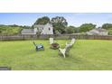 Spacious backyard with a fire pit surrounded by chairs and a fenced perimeter at 125 Drennan Dr, Fayetteville, GA 30215