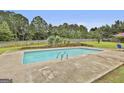 Backyard in-ground swimming pool surrounded by a concrete patio and lush green lawn at 125 Drennan Dr, Fayetteville, GA 30215