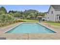 Backyard in-ground swimming pool surrounded by a concrete patio and lush green lawn at 125 Drennan Dr, Fayetteville, GA 30215