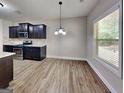 Bright dining area features stainless steel appliances, dark cabinets, and a window with natural light at 473 Cherry Creek Dr, Loganville, GA 30052