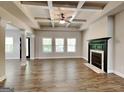Spacious living room featuring a modern fireplace, coffered ceilings, neutral tones, and ample natural light at 473 Cherry Creek Dr, Loganville, GA 30052