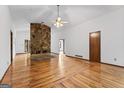 Open living room with hardwood floors and a stone fireplace at 655 Sunset Dr, Locust Grove, GA 30248