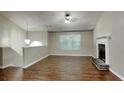 Spacious living room featuring hardwood floors, a fireplace, and abundant natural light from a large window at 426 Summer Hill Cir, Stockbridge, GA 30281