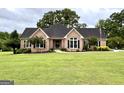 Well-maintained brick home with lush green lawn, classic black shutters, and mature trees at 10 Wigwam Cir, Whitesburg, GA 30185
