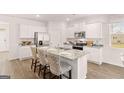 Modern kitchen featuring white cabinets, stainless appliances, granite countertops, and center island with seating at 351 Friendship Oak Way, Hampton, GA 30228