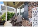 Close-up of front porch featuring rocking chairs and brick detail, creating a welcoming outdoor space at 372 Cobblestone Trl, Dallas, GA 30157