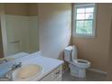 Simple bathroom with white sink, toilet, shower and a window providing natural light at 2763 Hunters Ct, Hampton, GA 30228
