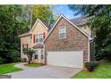 Charming home with a two-car garage, stone facade and nice landscaping on a wooded lot at 8330 N Sterling Lakes Dr, Covington, GA 30014