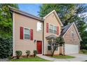 View of the charming home with red shutters and door and a manicured yard at 8330 N Sterling Lakes Dr, Covington, GA 30014