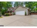 Lovely two-story home featuring a two-car garage and a long driveway surrounded by mature trees at 4080 Derby Dr, Cumming, GA 30040