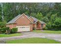 Red brick home with attached garage and circular driveway at 1214 Lambeth Se Way, Conyers, GA 30013