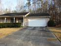 This single-story home has a wide driveway leading to a one car garage at 5848 Navarre Ct, Stone Mountain, GA 30087
