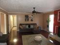 Inviting living room featuring hardwood floors, brown sofa with throw pillows, and a decorative ceiling fan at 5848 Navarre Ct, Stone Mountain, GA 30087