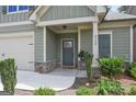 Inviting front porch with stone accents, a gray front door, and manicured landscaping at 3112 Patriot Sq, Marietta, GA 30064