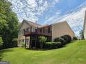 View of the back of the home with a large deck overlooking the backyard, surrounded by lush greenery at 133 Sea Island Dr, Peachtree City, GA 30269