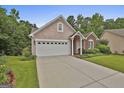 Charming home exterior with a two-car garage, arched entryway, and well-manicured landscaping at 133 Sea Island Dr, Peachtree City, GA 30269