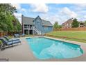 Backyard oasis featuring a sparkling pool, lounge chairs, and a covered patio perfect for entertaining at 150 Surrey Chase Dr, Social Circle, GA 30025