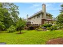 Expansive backyard featuring a wooden deck, lush greenery, and well-maintained landscaping, perfect for outdoor living at 1014 Overlook Dr, Villa Rica, GA 30180