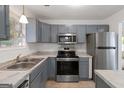 Bright kitchen featuring stainless steel appliances, gray cabinets, and white marble countertops at 4651 Garden Hills Dr, Stone Mountain, GA 30083