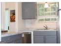 Modern kitchen with stainless steel sink, grey cabinets, and marble countertops at 4651 Garden Hills Dr, Stone Mountain, GA 30083
