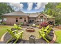 Inviting backyard area featuring a fire pit and green Adirondack chairs. Relax and enjoy the outdoor space! at 715 Branchview Ct, Mcdonough, GA 30252
