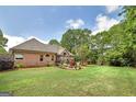 Large backyard with green lawn, trees and fire pit area creating a perfect space for outdoor enjoyment at 715 Branchview Ct, Mcdonough, GA 30252