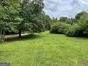Beautifully maintained lawn with mature trees, creating a peaceful outdoor space at 1470 Dunn Rd, Cumming, GA 30040
