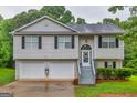 Charming two-story home features a two-car garage and a welcoming entrance with steps leading to the front door at 240 Mountain Ln, Covington, GA 30016