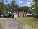 Classic ranch-style home with attached garage, driveway, and mature trees on a grassy lot at 416 Winterwood Dr, Stockbridge, GA 30281