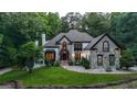 Elegant two-story home showcasing stone detailing, lush landscaping, and inviting walkway with soft lighting at 2878 Heather Row Sw Rdg, Lilburn, GA 30047