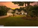 Beautiful home at sunset featuring manicured landscaping and warm exterior lighting at 134 Mellington Ln, Peachtree City, GA 30269