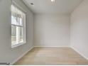 Sun-drenched bedroom featuring large window, neutral paint and hardwood floors at 221 Ruthe Cv, Locust Grove, GA 30248
