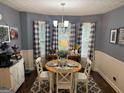 Cozy dining area with a round table, white chairs, a bay window, and decorative curtains at 1612 Cagle Ct, Lawrenceville, GA 30045