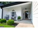 Inviting front porch with rocking chairs, a welcome sign, and a beautifully landscaped yard at 1612 Cagle Ct, Lawrenceville, GA 30045