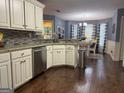 Elegant kitchen features white cabinetry, granite countertops, mosaic backsplash, stainless steel appliances, and hardwood floors at 1612 Cagle Ct, Lawrenceville, GA 30045