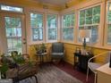 Bright sunroom with yellow walls, large windows, and comfortable seating area filled with natural light at 1612 Cagle Ct, Lawrenceville, GA 30045