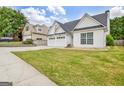 View of a charming home with a manicured lawn and a convenient three-car garage at 240 Turnbridge Cir, Peachtree City, GA 30269