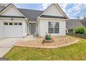 Close-up of a home with a well-maintained lawn and detailed landscaping around the entrance at 240 Turnbridge Cir, Peachtree City, GA 30269